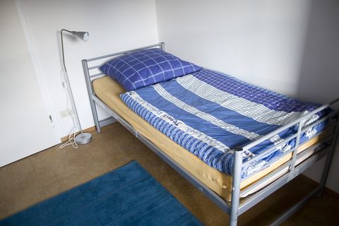 Zimmer 2: Einzelbett mit blau-weißer Bettwäsche